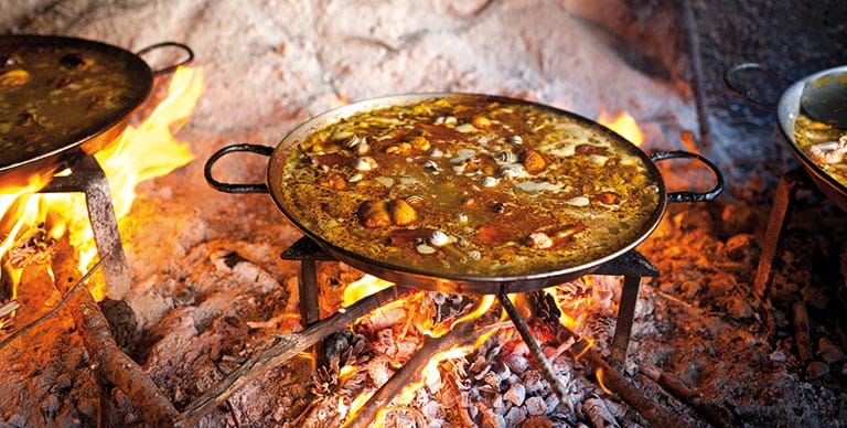 Traditional Valencian paella being cooked over an open fire